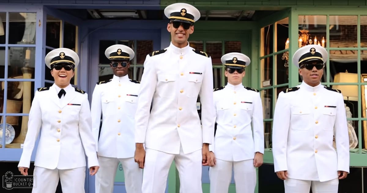 A group of young adults in uniform standing outside a building with decorative windows on an urban area during daytime.