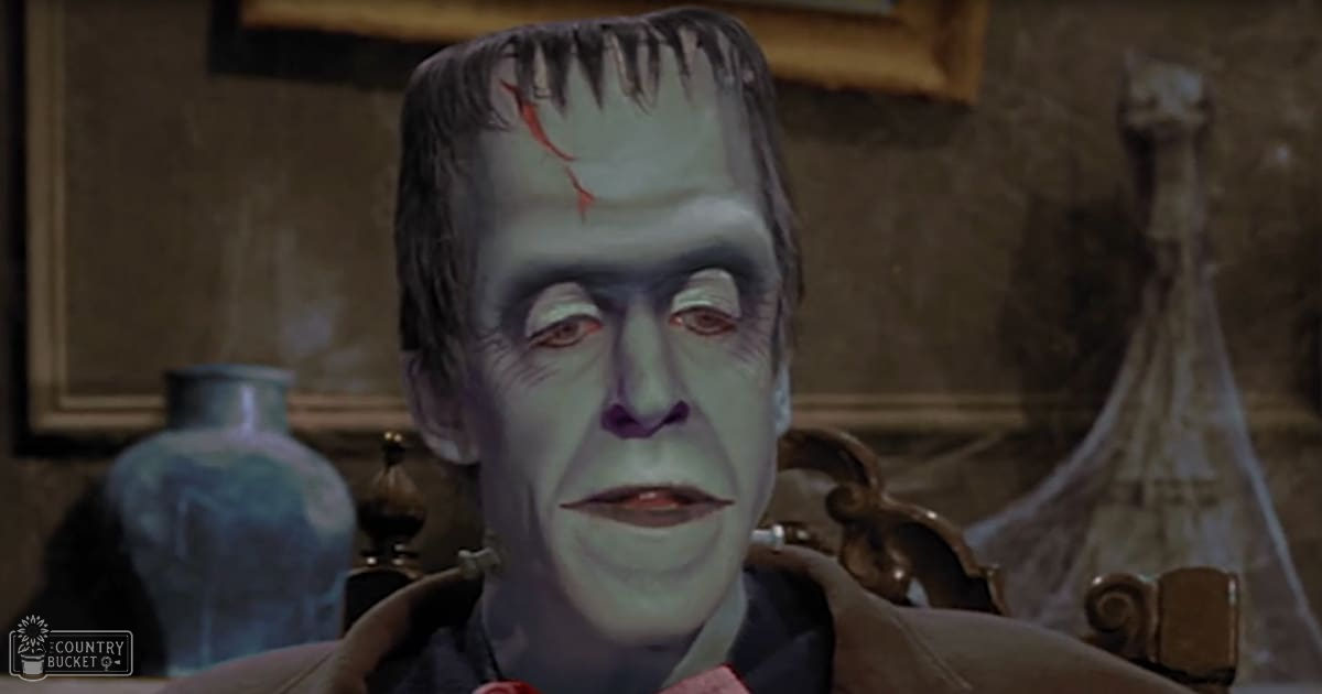 A character resembling Frankenstein’s monster stands indoors in an ornate setting with natural light filtering through.