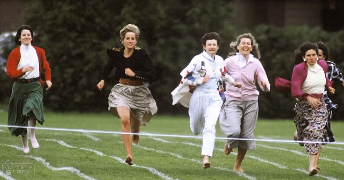 A group of women running outdoors in a park-like setting with trees and greenery in the background; late afternoon or early evening soft natural lighting.