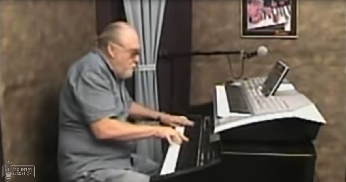An older adult male playing a keyboard in what appears to be a home setting, surrounded by sheet music and a microphone.