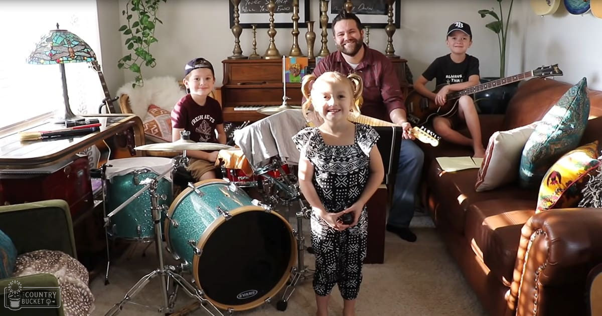 A cozy living room with a mix of vintage and modern decor elements, with children playing musical instruments and adults smiling.