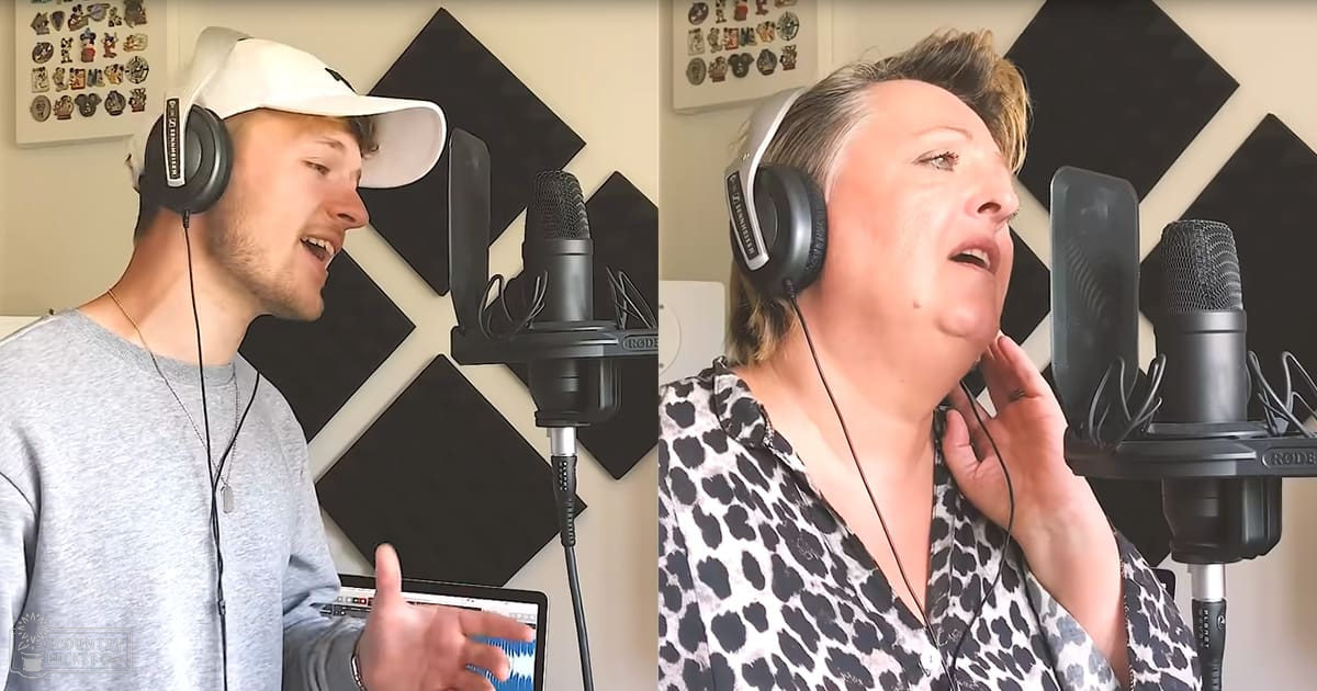 Young adult male in a home recording studio with acoustic foam panels, wearing a gray long-sleeve shirt and white baseball cap, alongside an older female middle-aged individual dressed in a leopard print blouse. The setting includes two microphones on stands, a laptop displaying audio waveforms, and framed small items on the wall.