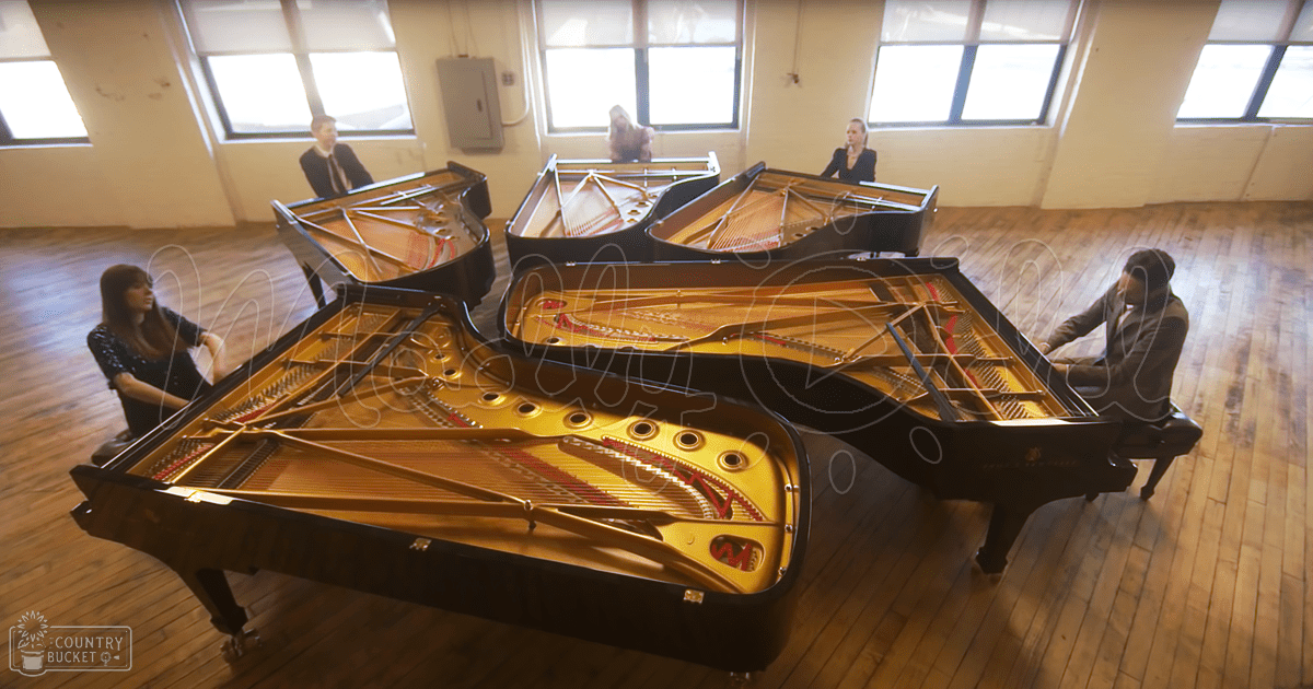 A group performance involving grand pianos in an indoor setting, likely a rehearsal space or music studio.
