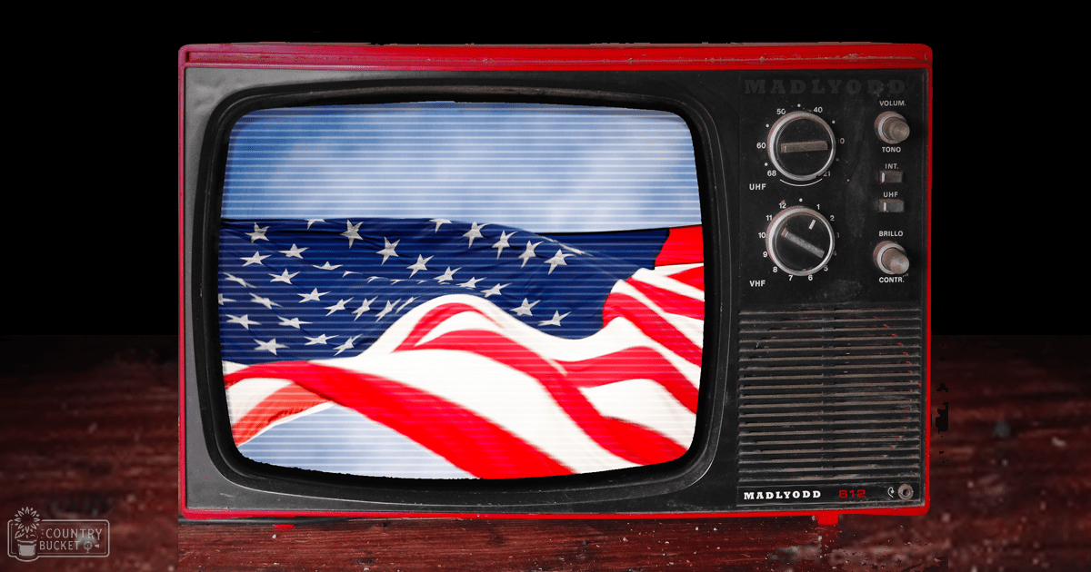 An old television set displaying a U.S. flag indoors with 'MADLYODD' written on its side, set against a dark background.