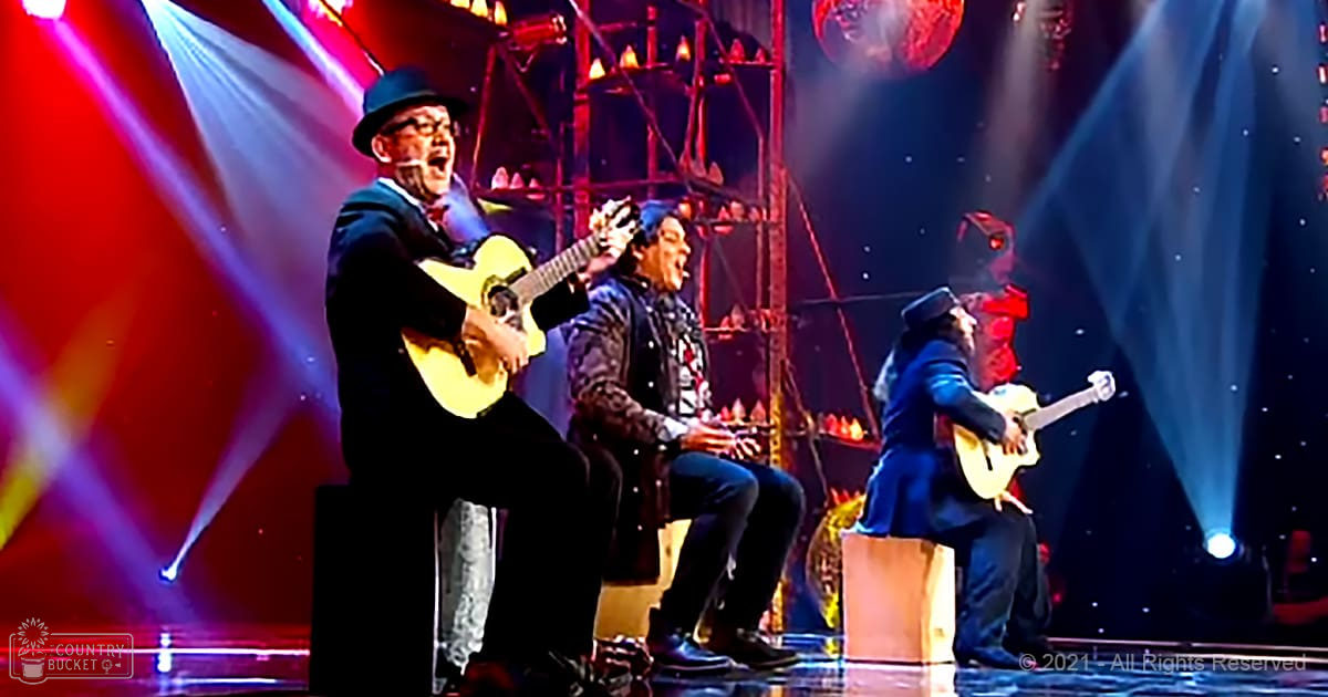 A theatrical stage performance with older adult male singers in formal attire, with a decorative dragon-like structure behind them under dramatic lighting.