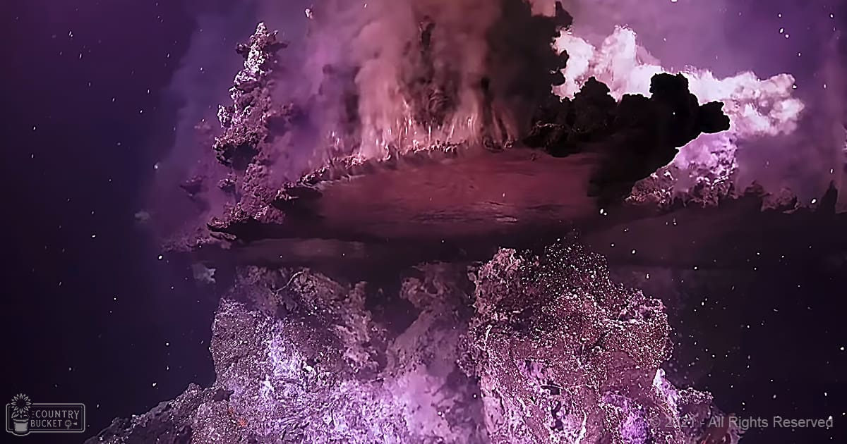A volcanic eruption on an extraterrestrial landscape with a barren, rocky terrain under a dark sky filled with stars and illuminated by purplish artificial lighting.