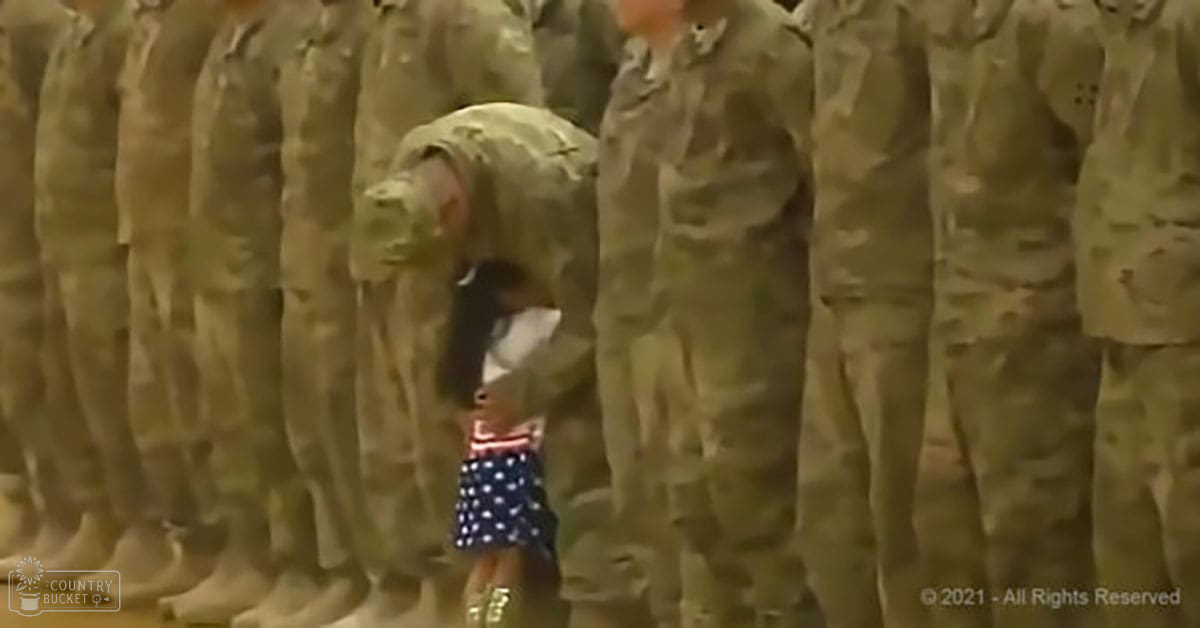 A toddler in a polka-dotted dress interacting with soldiers indoors under even lighting.