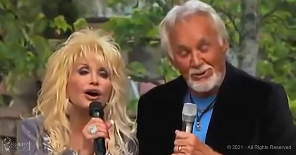 An outdoor musical performance scene with an adult female in a dark patterned top, an older male in a blazer and light blue shirt under soft natural daylight amidst greenery.