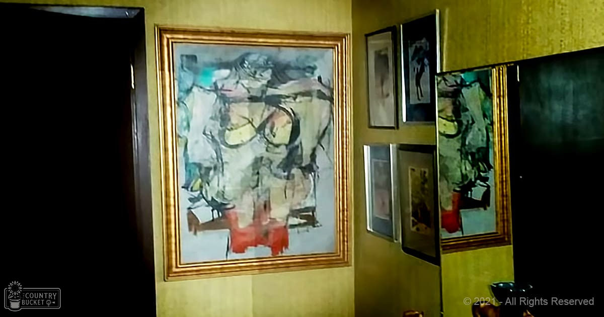 Abstract painting with multiple colors on a yellow wall in an indoor setting.