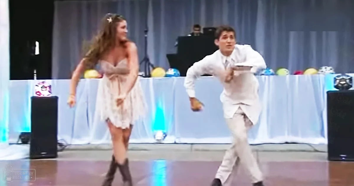 Teenage dancers performing at a school function with stage curtains, balloons in blue, yellow, and red.