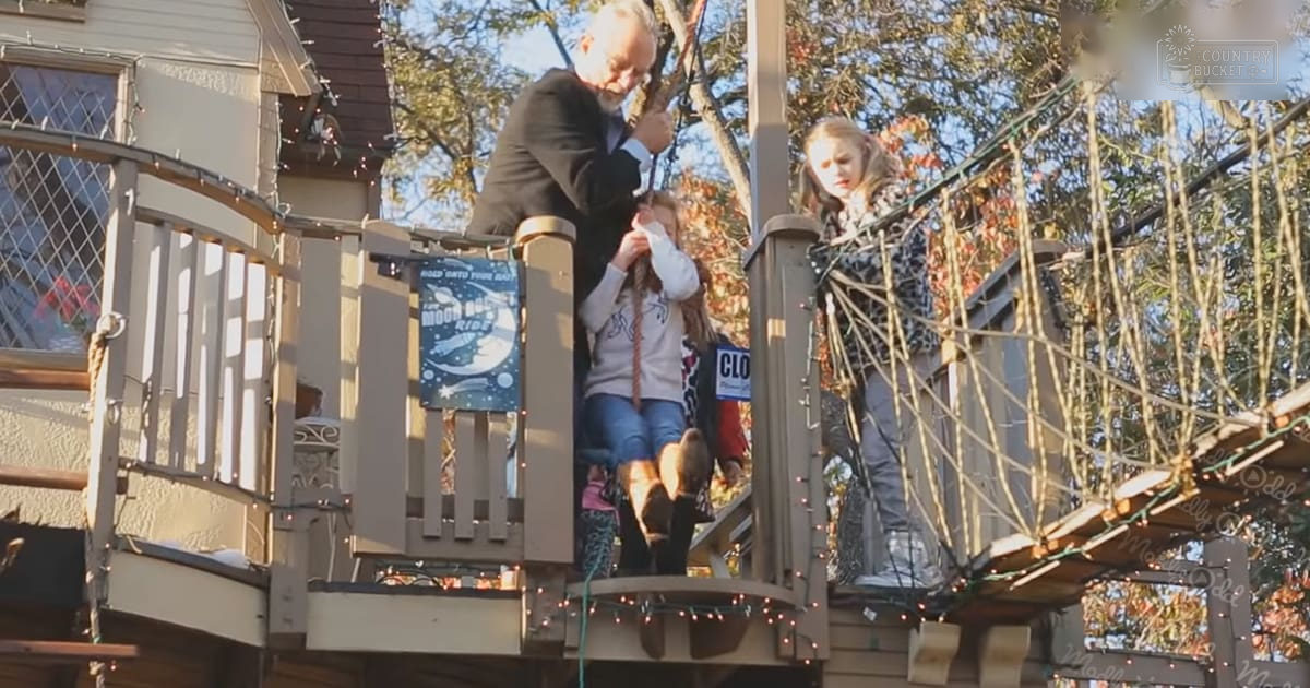 A family enjoys an outdoor activity at a festive amusement park during fall, with autumn-colored trees and string lights.