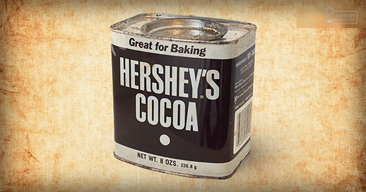 A Hershey's cocoa tin can labeled 'Great for Baking' against a beige textured background, likely an indoor setting during daytime.