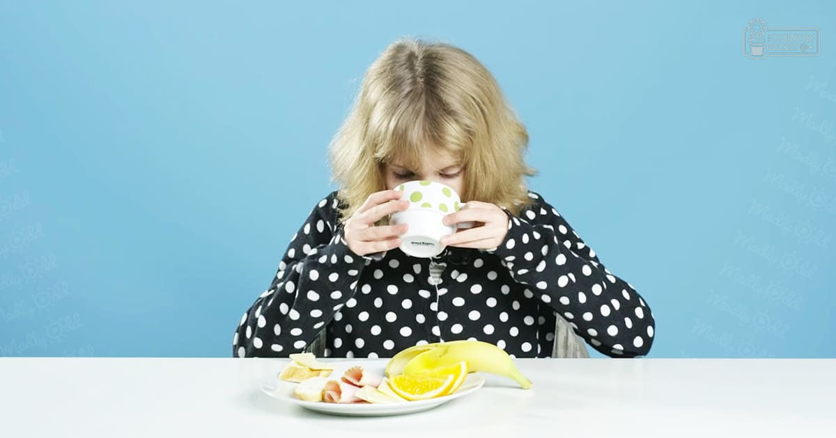 A young adult female in a loose, polka-dotted long-sleeved shirt stands indoors against a blue wall with 'Madly Odd' text.