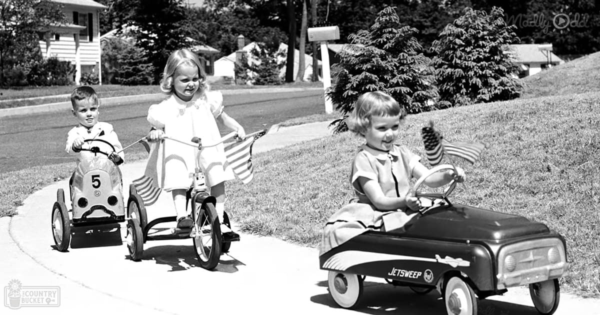 Children playing with toy cars in a suburban neighborhood on a sunny summer day.