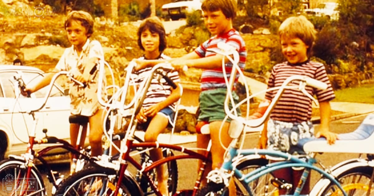 Group of children with bicycles in a residential outdoor setting during daytime.