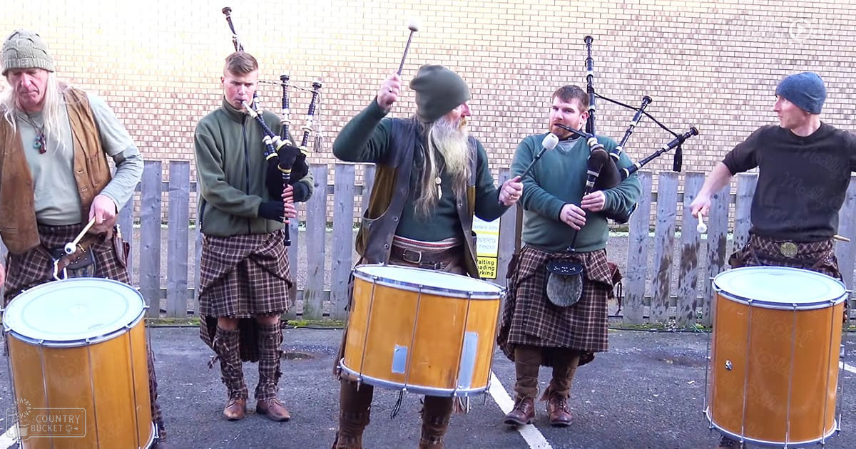 A group performing traditional Scottish music outdoors under overcast skies.
