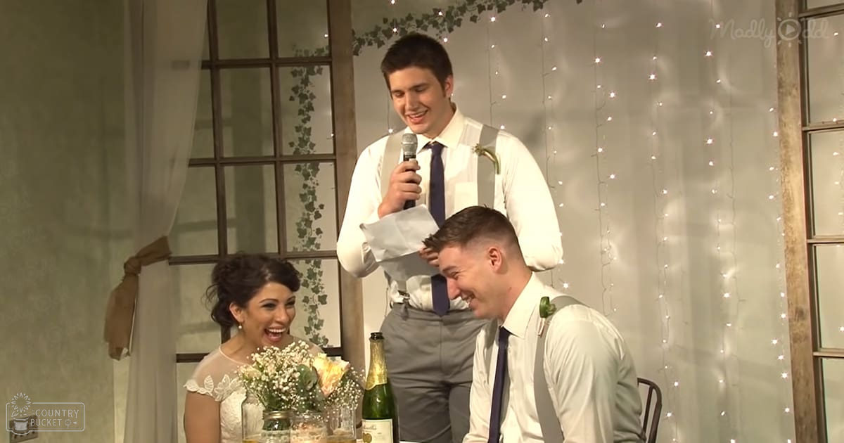 A wedding scene with a young adult female bride in a white lace bridal gown and two groomsmen in matching attire, set against an indoor venue decorated with fairy lights and greenery.