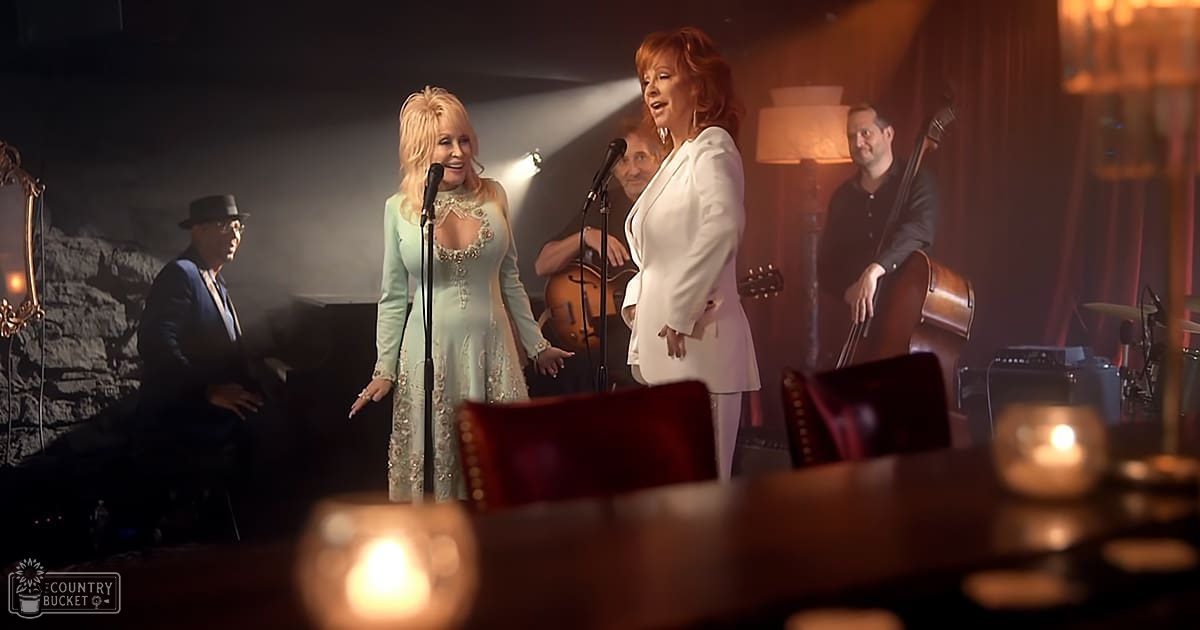 Musical performance in an intimate bar or lounge setting with a female singer, patterned dress, and cozy decor.