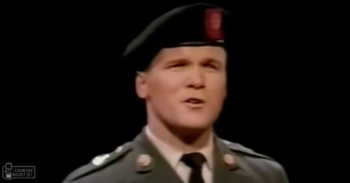 Young adult male in military uniform, likely mid-20th century, indoors with controlled lighting on stage.