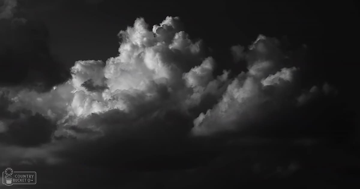 Clouds fill an outdoor sky, dark tones suggest nighttime or early morning