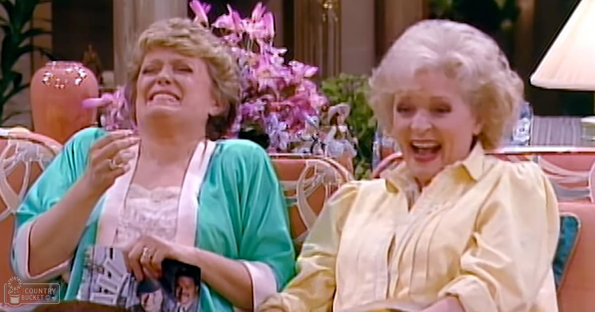 Two older adult women indoors in a living room setting with ornate decor and natural light.