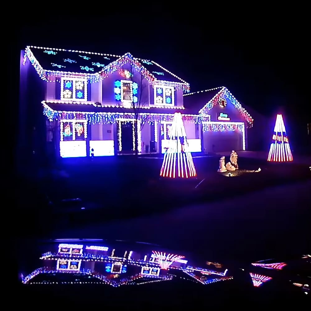 A residential neighborhood decorated with colorful Christmas lights during winter season.