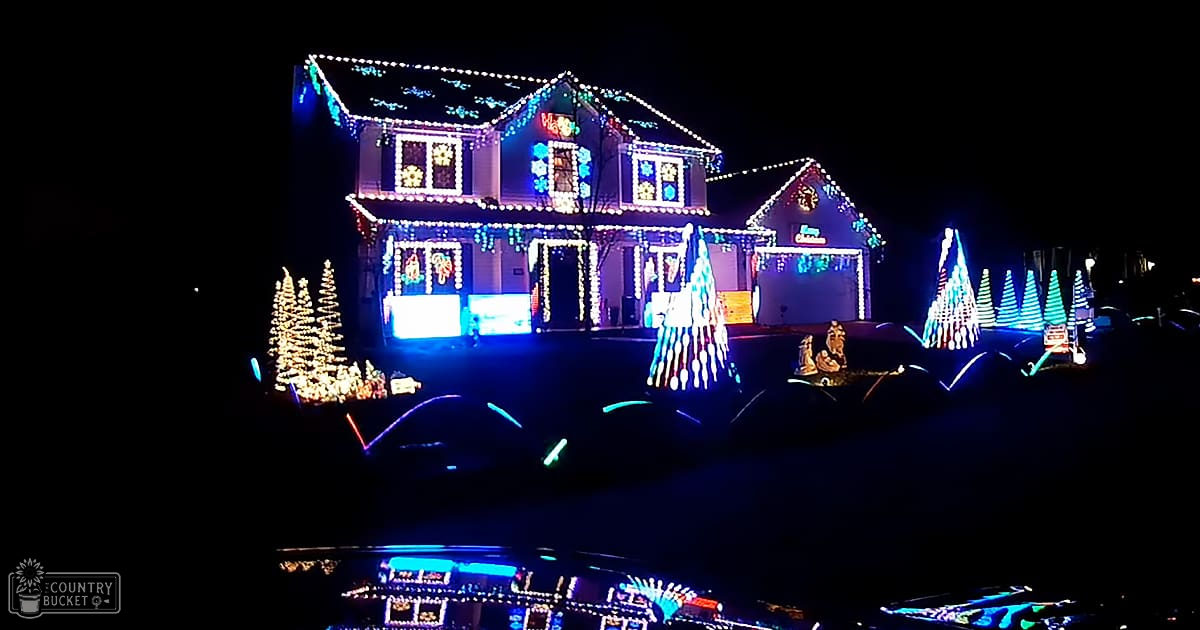 A residential neighborhood decorated with colorful Christmas lights during the nighttime holiday season.