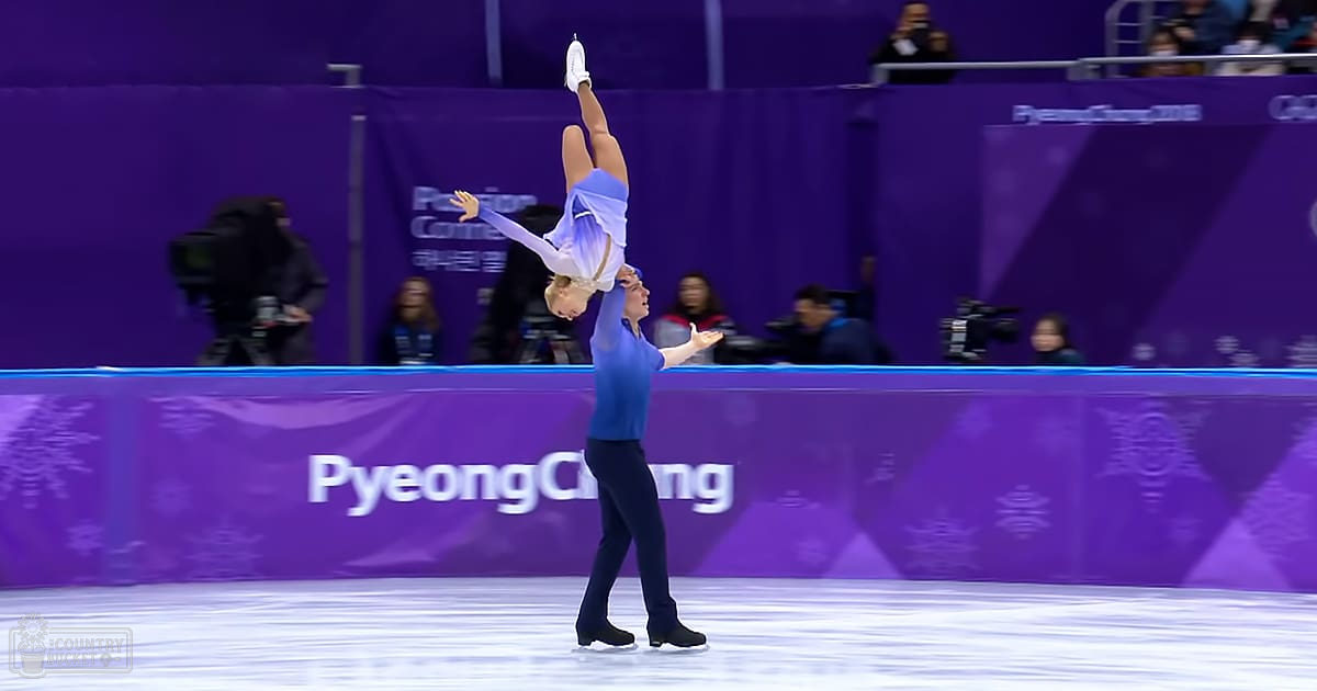 Two figure skating pairs in action at PyeongChang 2018 Winter Olympics, with one skater mid-air wearing a light blue leotard and the other on the ground in athletic attire. The setting is an indoor ice rink illuminated by artificial lights.
