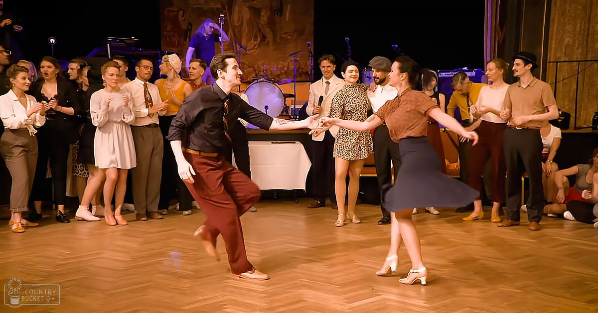 An adult male singer performing on a stage in front of an audience at what appears to be a formal indoor event space during the evening.