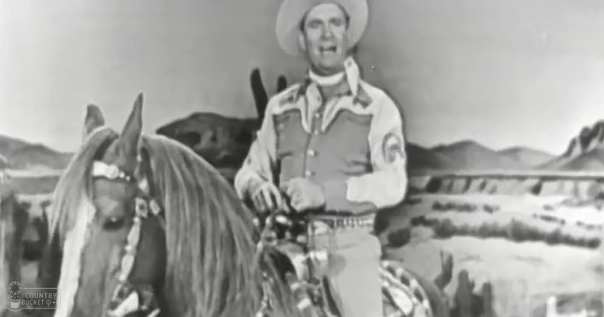 A cowboy in a desert landscape wearing a white shirt with long sleeves and a dark vest over it, accompanied by a dark-coated horse with white markings on its face.