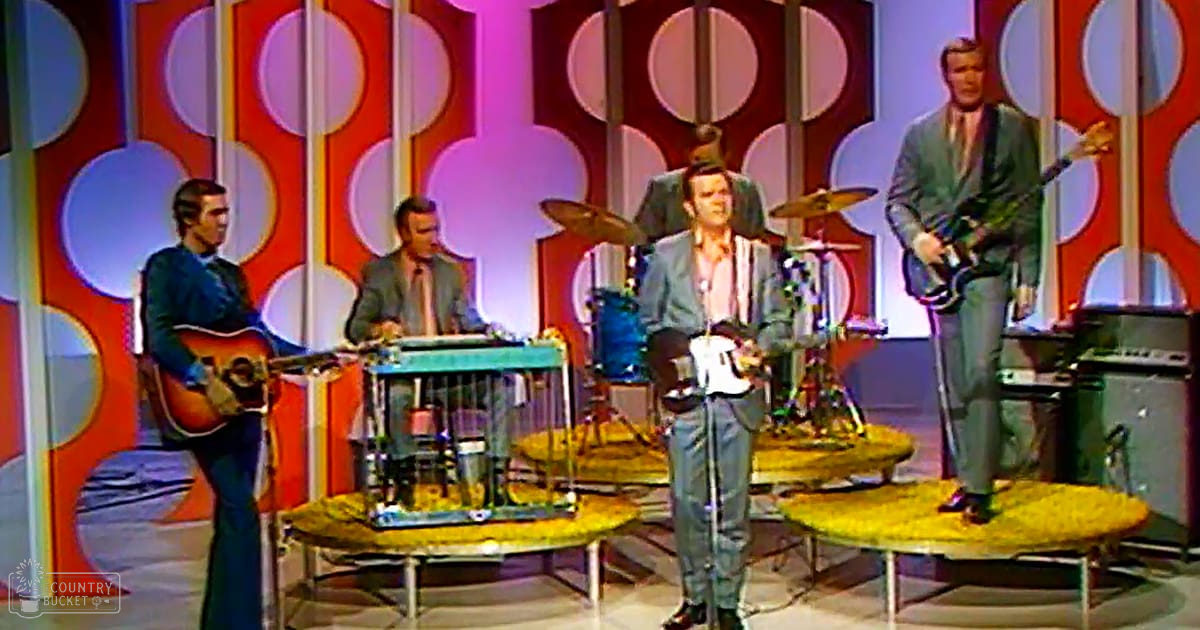 A musical performance by four adult male musicians in a vibrant, retro-style studio with red and white circular patterns against a blue-gray wall.