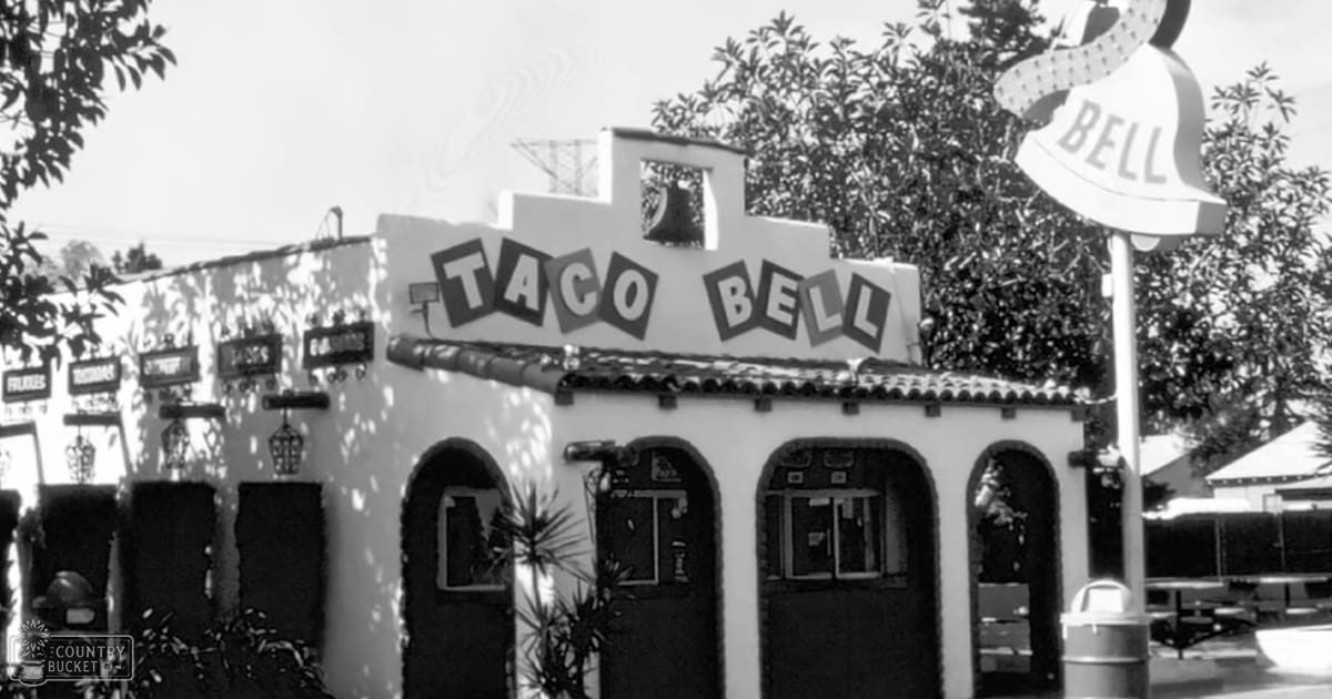 Taco Bell restaurant exterior with Spanish-style architecture and iconic sign in an outdoor setting during daylight hours.