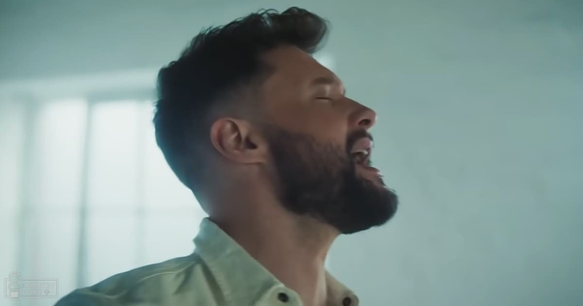 A young adult male wearing a modern casual light green button-up shirt with regular fit and collar stands indoors against light-colored walls under natural daylight.