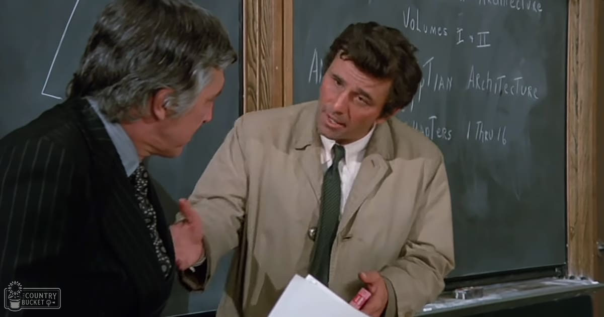Two middle-aged men in a classroom setting, dressed formally from the mid-20th century, engaged in conversation with chalkboards displaying academic text behind them.