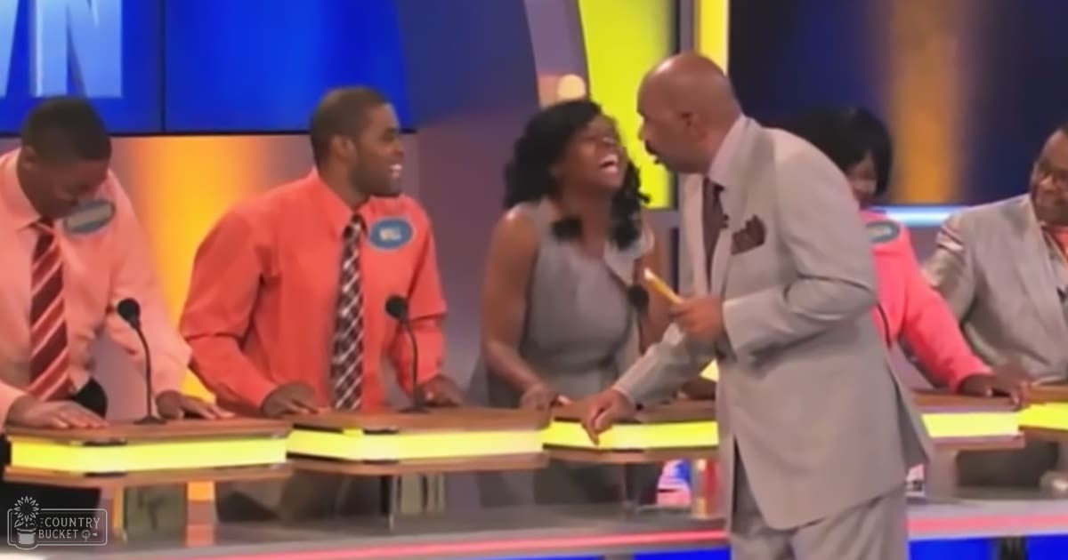 A game show setting with contestants and a host in an indoor studio with vibrant blue and yellow panels.