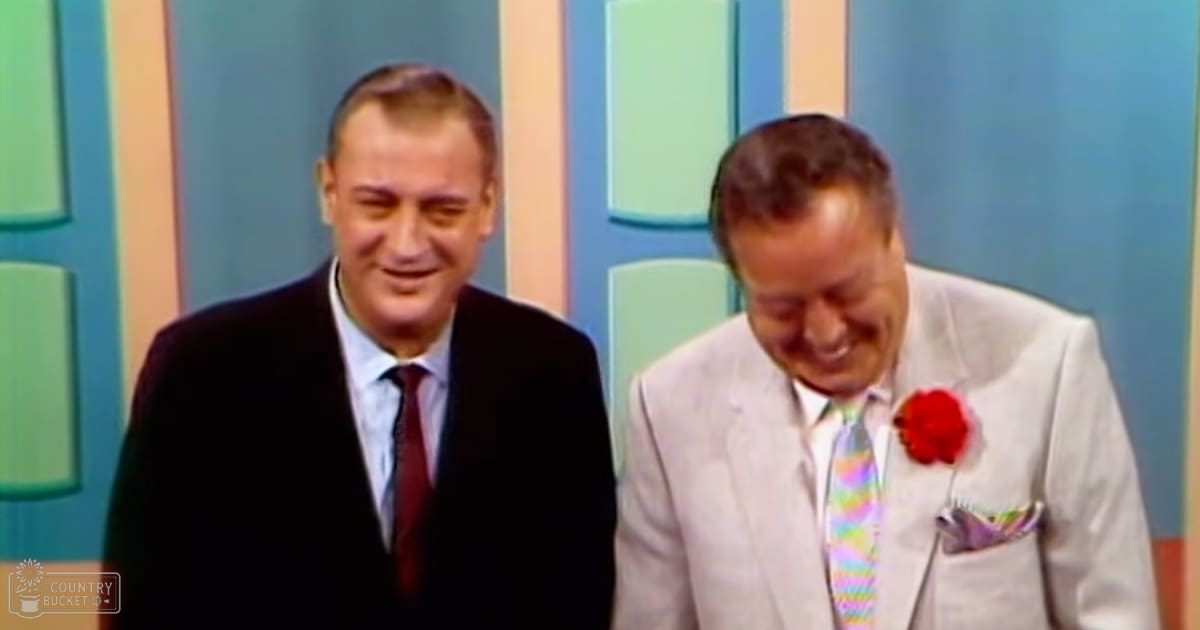 Two middle-aged men in formal attire, wearing suits with distinct accessories against a colorful studio backdrop.