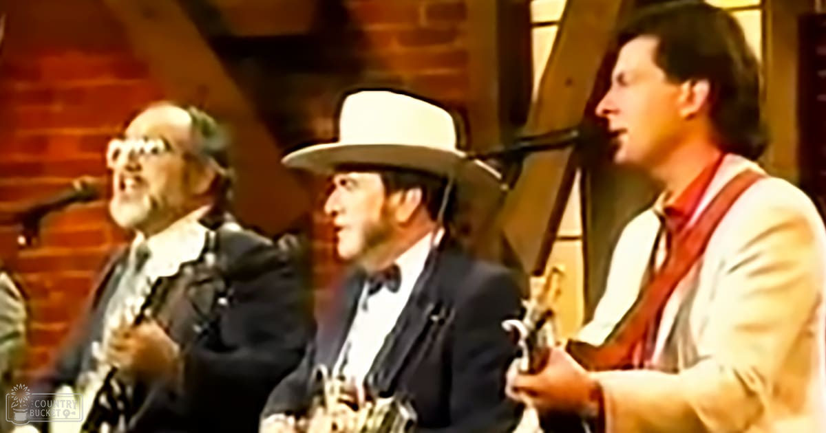 An indoor Western-themed scene set in the late 19th century, with three adult males dressed in formal attire and holding revolvers, with brick walls and wooden beams suggesting a saloon or stagecoach stop atmosphere.