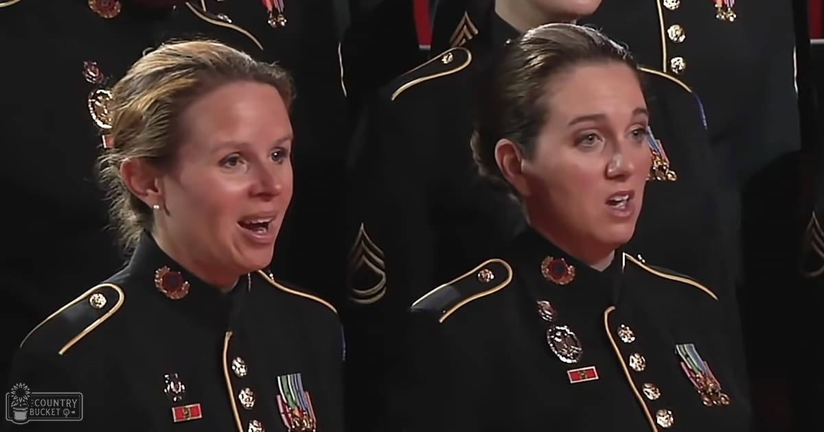 Two adult females in formal military uniforms adorned with medals and ribbons, participating in what appears to be a ceremonial event indoors.