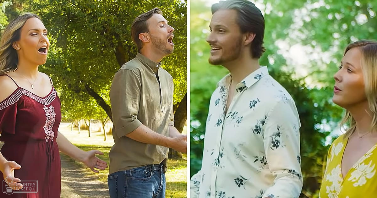 A group of four young adults singing outdoors in a park-like setting with trees and greenery in the background, wearing casual summer attire.