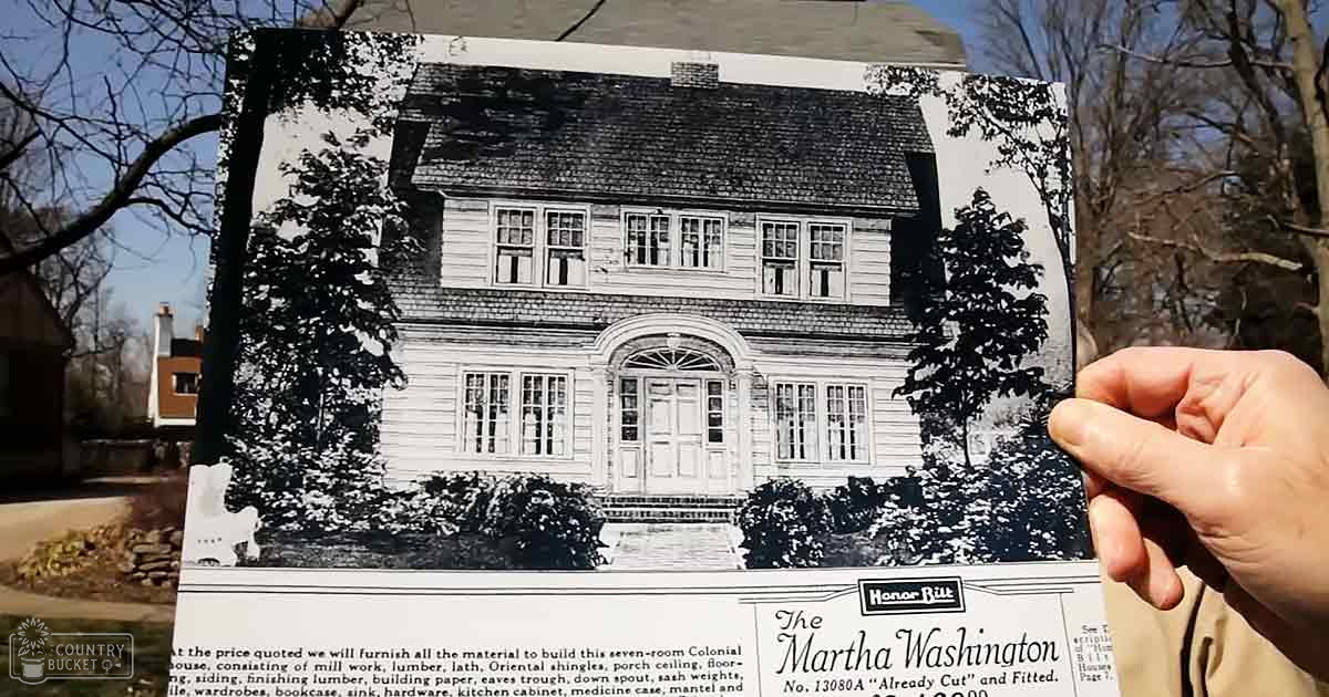 An outdoor scene with bare trees against a residential backdrop during late fall or winter, with a vintage advertisement for 'The Martha Washington' house model prominently displayed.