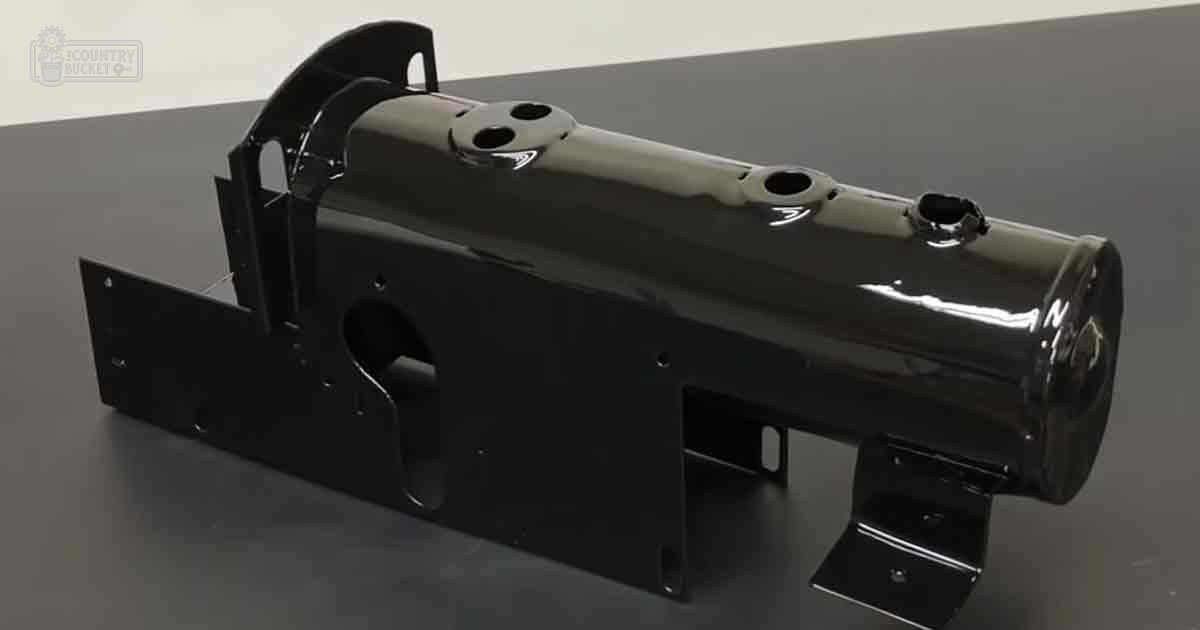 A close-up view of a black metal automotive part with mounting brackets, set against a neutral studio backdrop.
