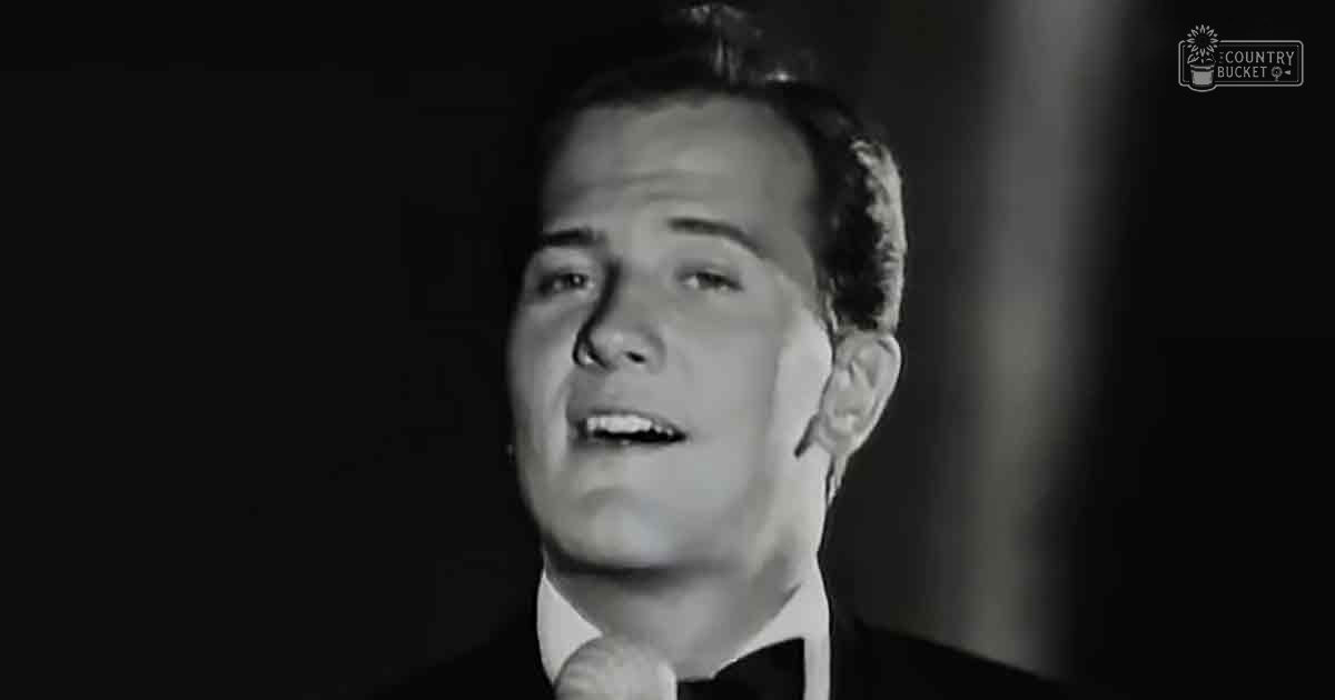 Young adult male wearing a formal suit jacket with a collared shirt under an indoor setting with controlled lighting.