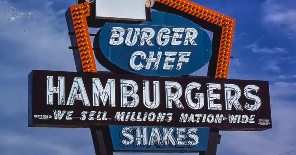 A retro Burger Chef neon sign advertising hamburgers and shakes under a clear sky during daytime.