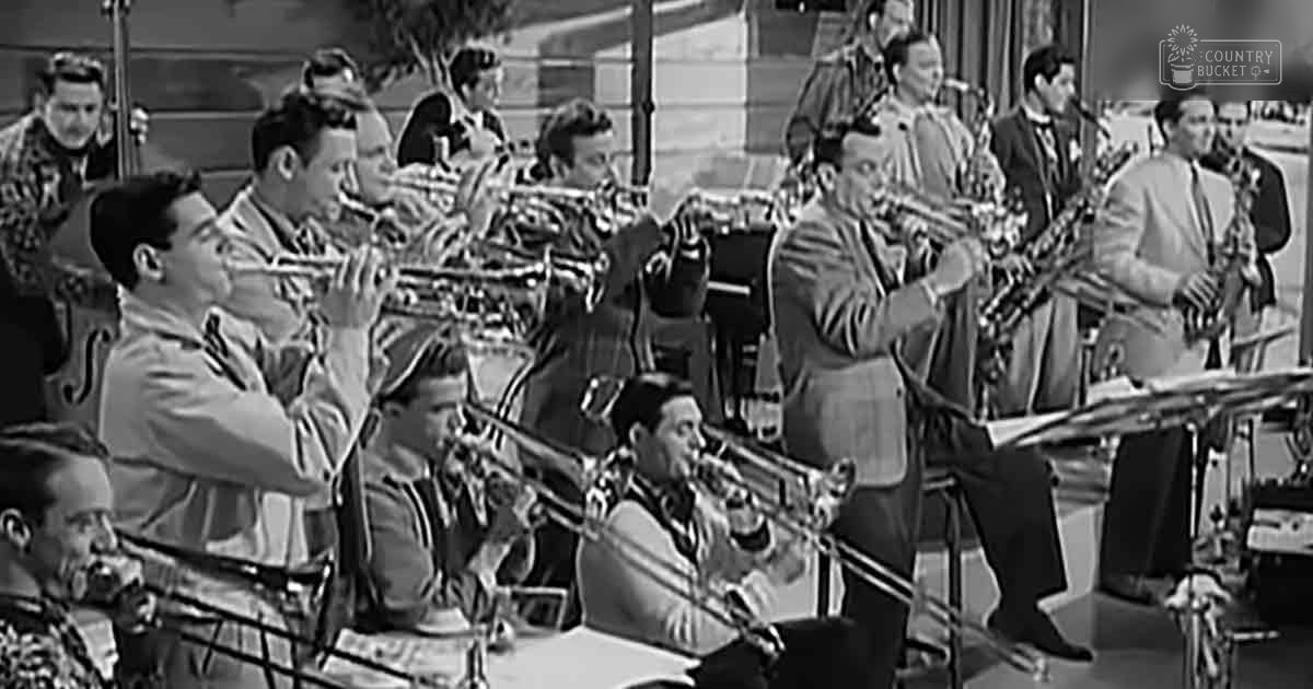 A jazz band performance in an outdoor urban setting with railings behind them during spring or summer daylight.