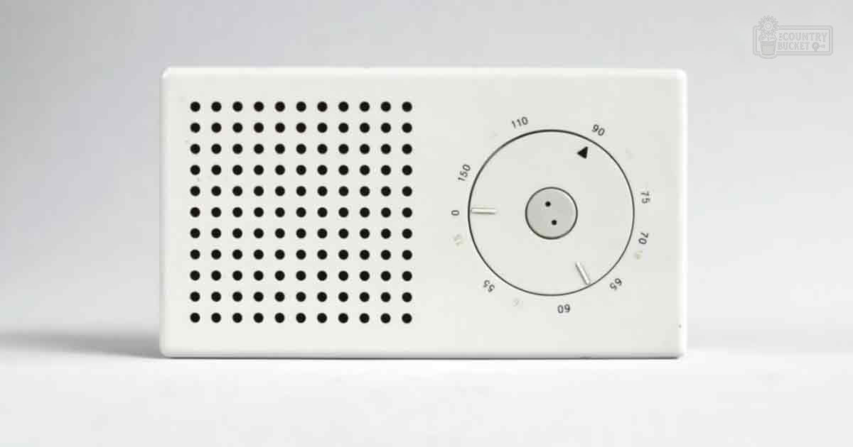 An indoor scene with a wall-mounted air purifier or thermostat with perforated holes, a circular dial, and small black dots.