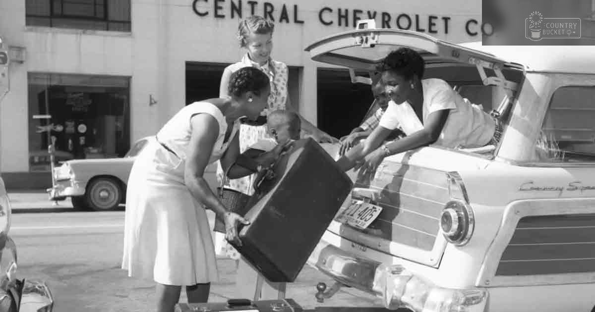 A woman loading luggage into a vintage Chevrolet car at Central Chevrolet Co., likely mid-20th century.