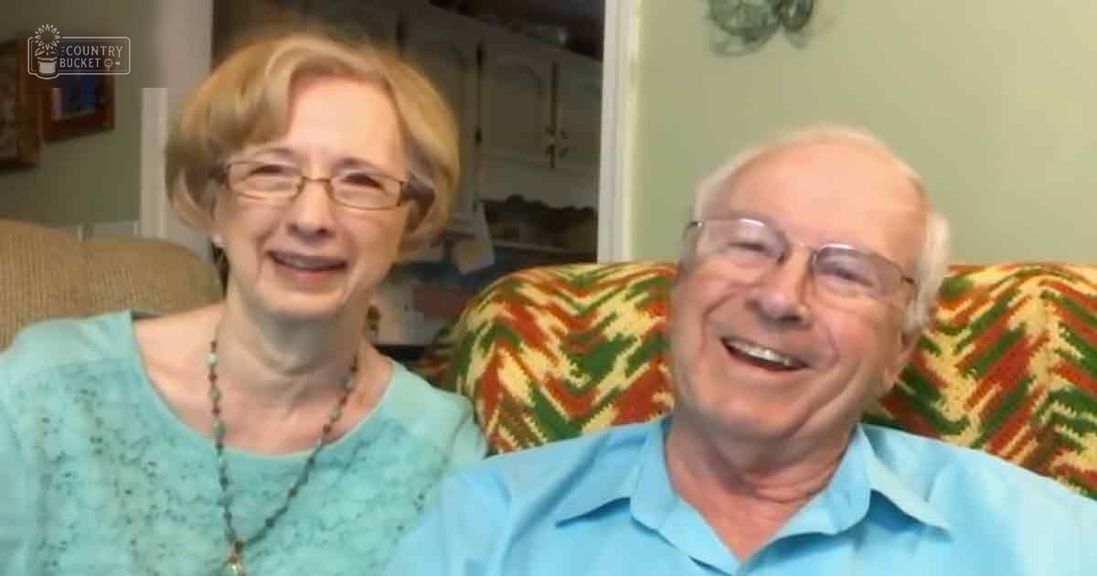 An older couple in a cozy living room setting, surrounded by home decor and soft daylight.