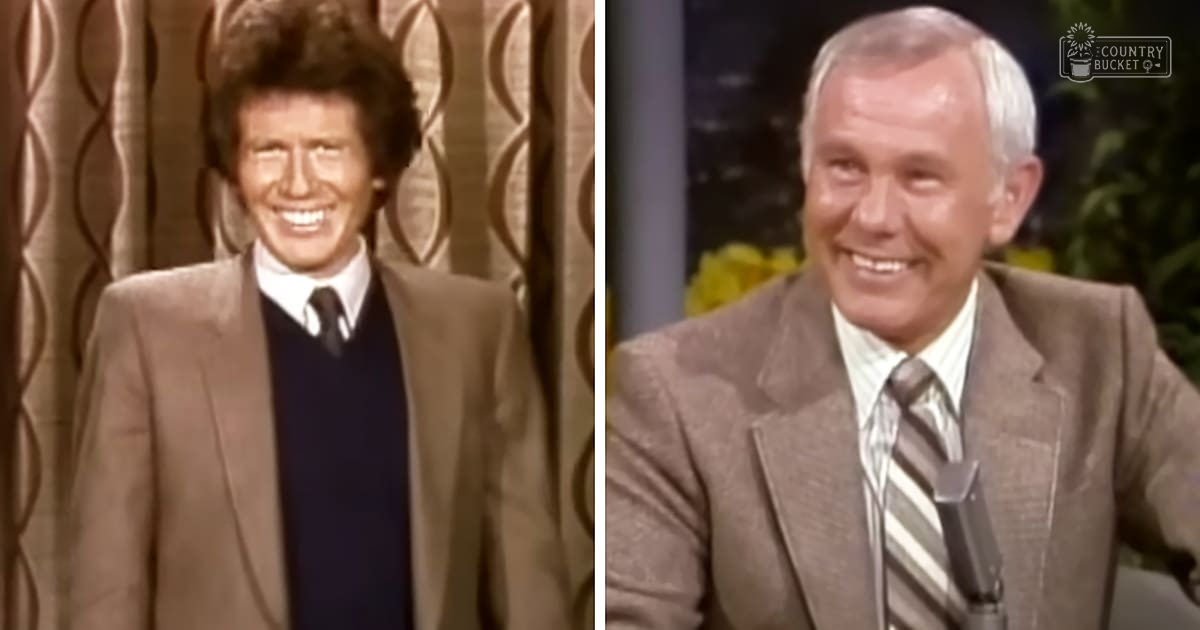 Adult male singer in brown textured blazer and dark blue sweater vest, middle-aged man in brown striped suit jacket and light-colored shirt with gray-striped tie, studio backdrop with swirling gold curtains, indoor lighting typical of a television production.