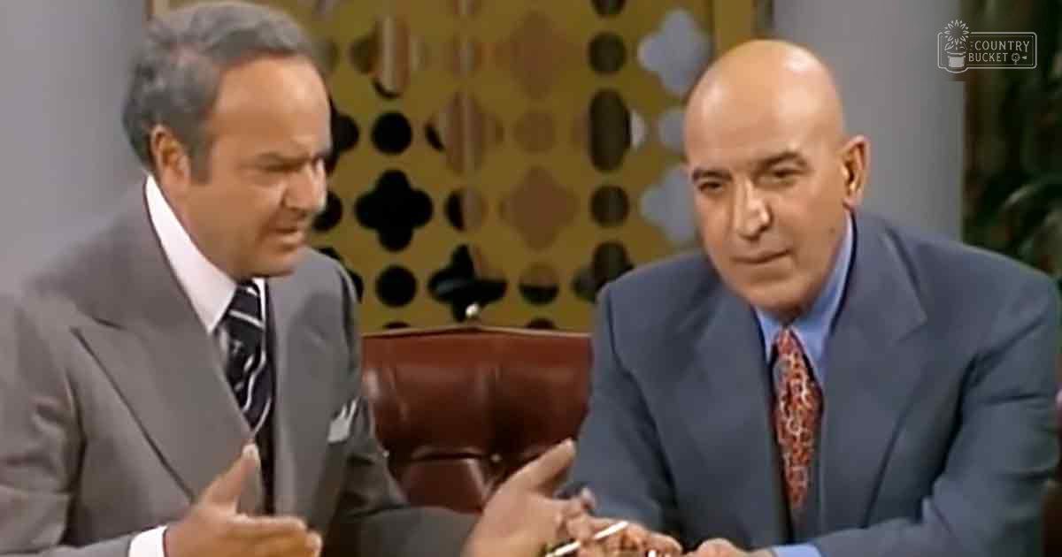 Two adult men in a mid-20th century studio setting, dressed formally for what appears to be an interview or talk show segment.