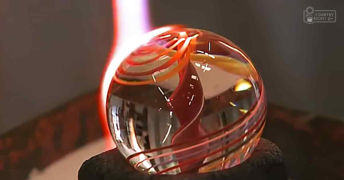 Glassblowing process in progress at an indoor workshop setting